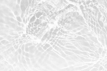 White water with ripples on the surface. Defocus blurred transparent white colored clear calm water surface texture with splashes and bubbles. Water waves with shining pattern texture background.