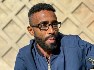 Smiling cheerful adult african american ethnicity man with a beard and glasses. A happy confident...