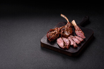 Juicy meat on the bone or rack of lamb. Grilled veal with salt, spices and herbs