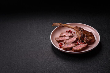 Juicy meat on the bone or rack of lamb. Grilled veal with salt, spices and herbs