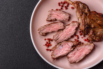 Juicy meat on the bone or rack of lamb. Grilled veal with salt, spices and herbs