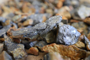 Antimony (Sb) mine, mining. Stibnite ore (antimonite, antimony trisulfide) background. Critical mineral, raw material. Metal used solder, bullets, plain bearings, alloys, lead-acid batteries