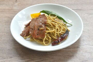 fried spaghetti topping crispy pork bacon and slice dry chili with bell pepper on plate   