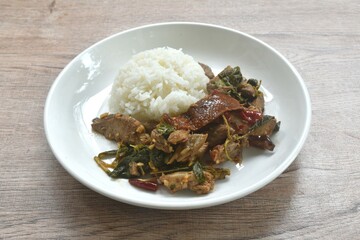 spicy stir fried slice sweet roasted duck meat with chili and basil on rice in plate