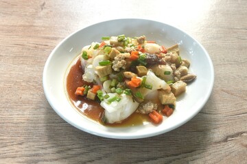 steamed large rice noodles topping chop pork and dice tofu with carrot dressing black soy sauce on plate 