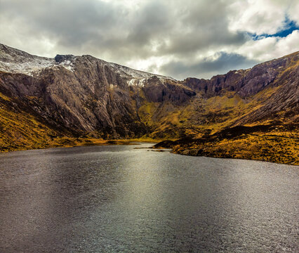 An aerial view above lake Idwal towards the corrie rear wall in Snowdonia, Wales in springtime
