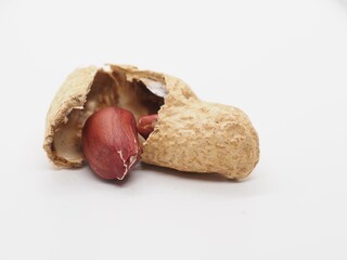 Close-up of raw peanuts with shell and kernel on white background.