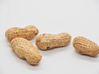 Close-up of raw peanuts with shell and kernel on white background.