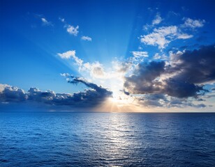 a sunburst over a tranquil ocean with a blue sky and dramatic clouds