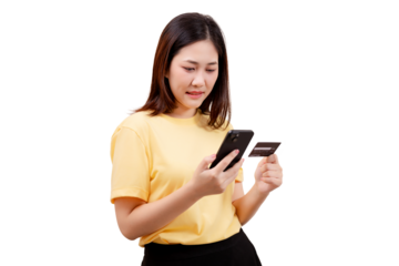 Asian young beautiful woman in a yellow shirt holds a smartphone and a credit card, appearing to make an online transaction.