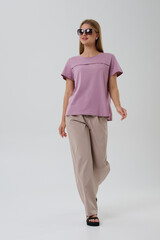 Obraz premium Girl model in casual clothes on a gray background posing in the studio