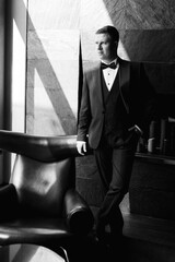 portrait of groom in blue tuxedo in hotel
