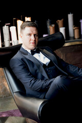 portrait of groom in blue tuxedo in hotel