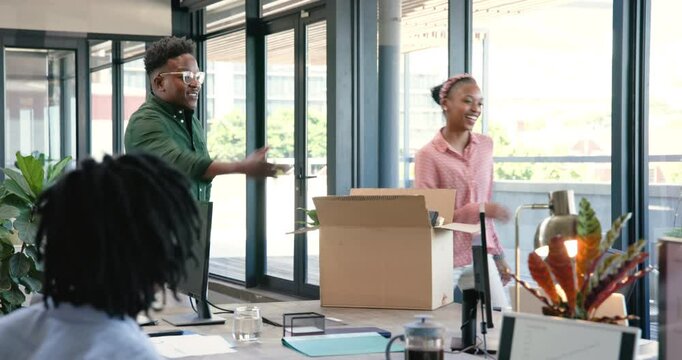 Carrying moving box, African American coworkers entering office on first day and greeting team
