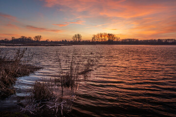 Still Lake and Reeds Under Colorful Evening Sky