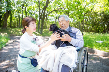 ペットセラピー　犬と嬉しそうな老人とヘルパー