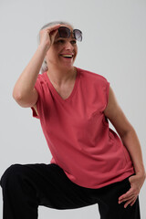 Woman in casual clothes posing in studio on grey background.