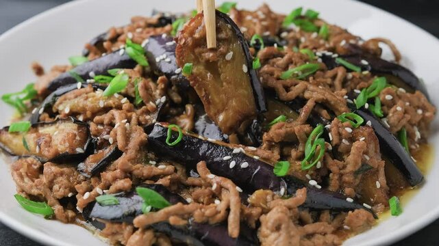 Eating Chinese Eggplant stir fry with minced pork and garlic sauce