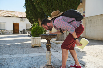 Tourist Drinking from a Public Fountain in a Charming Urban Square