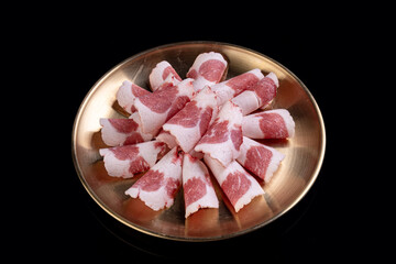 Beautifully arranged, tender slices of marbled meat lie in a circular pattern on a golden plate, perfect for sharing at a festive gathering or dinner party celebrating flavors