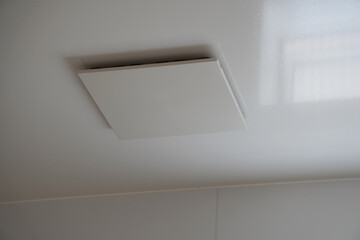 Ceiling Vent Fan in a Bright White Bathroom（明る白い浴室の天井にある換気扇）