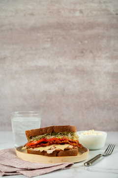 Deli sandwich with turkey, swiss cheese, bacon, sprouts and tomato