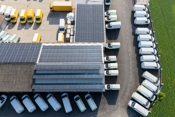 Delivery vans and trucks hub with solar panels on a roof. Fleet of vehicles.