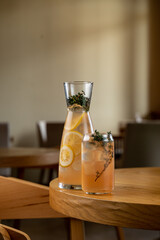 A beautifully arranged glass carafe and tumbler showcase a refreshing herbal lemonade infused with...