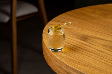 A beautifully crafted cocktail, featuring a vibrant garnish, sits elegantly on a smooth wooden...