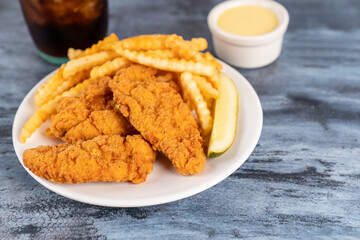 Fried chicken tenders with fries, pickle, drink and cookies 