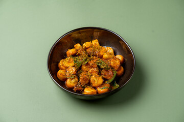 Nestled in a glossy black bowl, the gnocchi showcases a medley of textures and flavors, enhanced by a sprinkle of herbs. This culinary delight invites a sensory journey through vibrant tastes