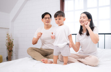 Fototapeta premium Before putting the kids to bed, parents, and kid unwind and play in the bedroom