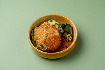 This dish showcases a golden-brown patty artfully placed atop a vibrant mix of greens, accented with delicate garnishes. A feast for both the eyes and taste buds awaits