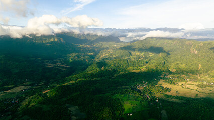 Naklejka premium Drone capture of jungle-clad mountain peak during golden hour
