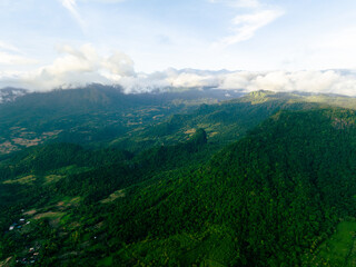 Obraz premium Drone view of mountain covered in rainforest at twilight