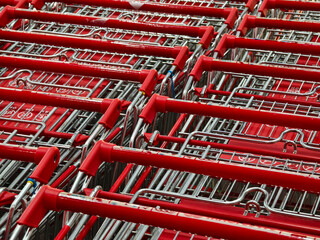 A row of shopping carts is neatly lined up in a straight row