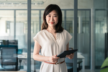 Portrait at camera Asian mature woman ceo analyst manager using tablet for business work, learning...