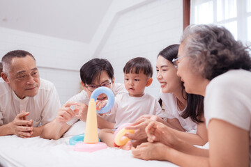 Fototapeta premium Before putting the kids to bed, parents, grandparents, and kid unwind and play in the bedroom
