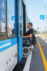 Wheelchair user using accessible train travel approaches a train at a station. The user prepares to board as the train door opens, with clear signage in the background.