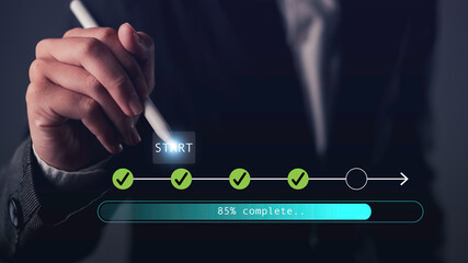 Hand holding stylus pointing at digital start button with progress bar and checklist icons, symbolizing process tracking, workflow progress, task completion, and digital planning.
