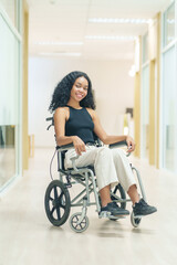 portrait african woman afro client sitting on wheelchair at corridor,getting service at hospital