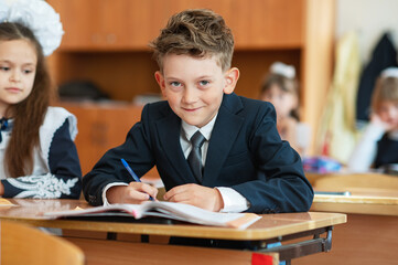 A satisfied pupil is sitting at a desk in a classroom. Education. Back to school.