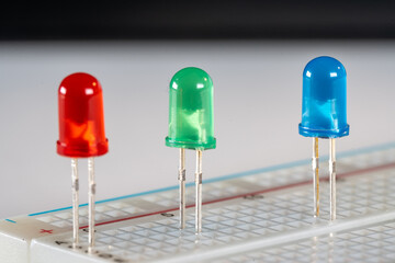 Close-up macro of red green and blue LED diodes stuck in breadboard