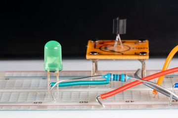 Macro of scientific class electric development board setup with wiring resistors LED and electric...