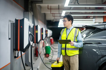 asian Male engineer working with digital tablet in charging station