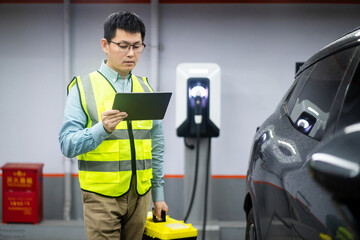 asian Male engineer working with digital tablet in charging station