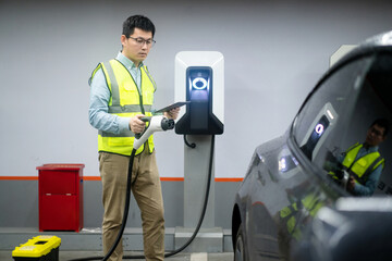 asian Male engineer working with digital tablet in charging station