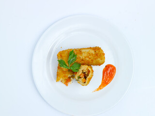 Top view of Crispy vegetable rissole cut open on a white plate, served with chili sauce. isolated on white background