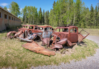 Three old rusted automobiles at the town of Nordegg, Alberta, Canada