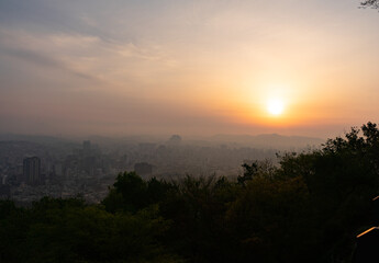 Sunrise cityscape in natural style, warm orange and green tones, Seoul South Korea Namsan Mountain, peaceful morning